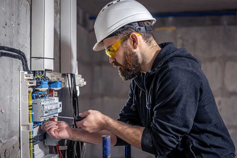A person turning off a circuit breaker switch in a residential electrical panel.