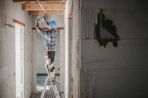 Parent secures a tamper-resistant outlet while a child plays safely nearby in a bright home.