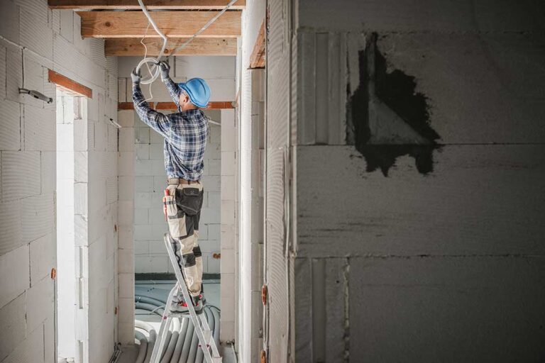 Parent secures a tamper-resistant outlet while a child plays safely nearby in a bright home.